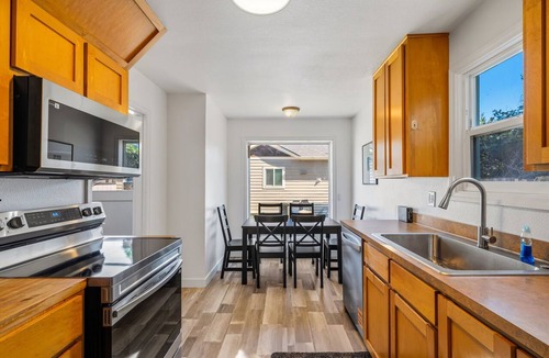 Downtown Vancouver House | Freshly renovated home with brand-new appliances, a new big-screen TV, refinished hardwood floors, and all-new furniture throughout. Sink into the plush leather sectional (pull-out queen sleeper) or dine at the six-seat table in the garden.
